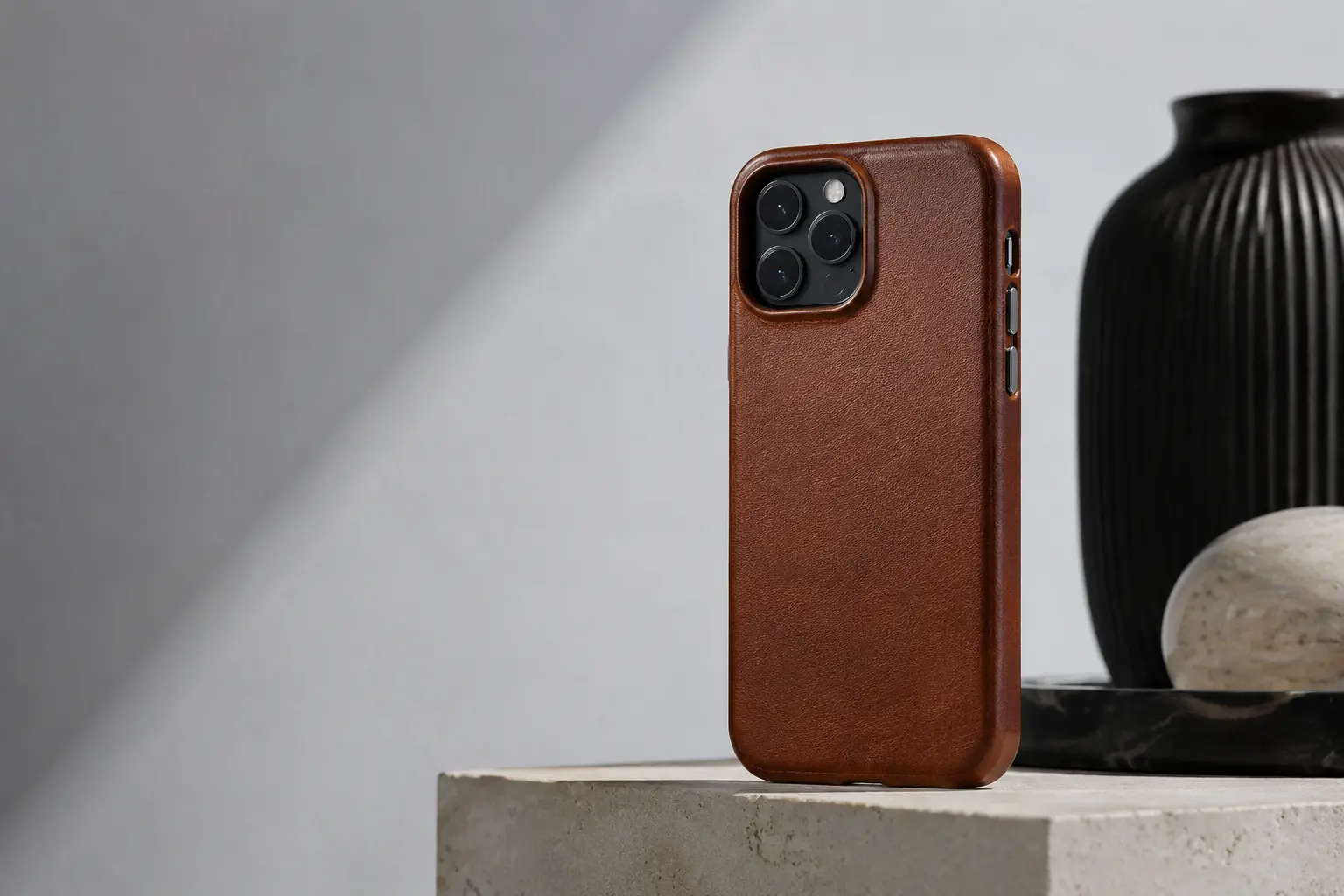 A premium brown leather smartphone case on a stone pedestal